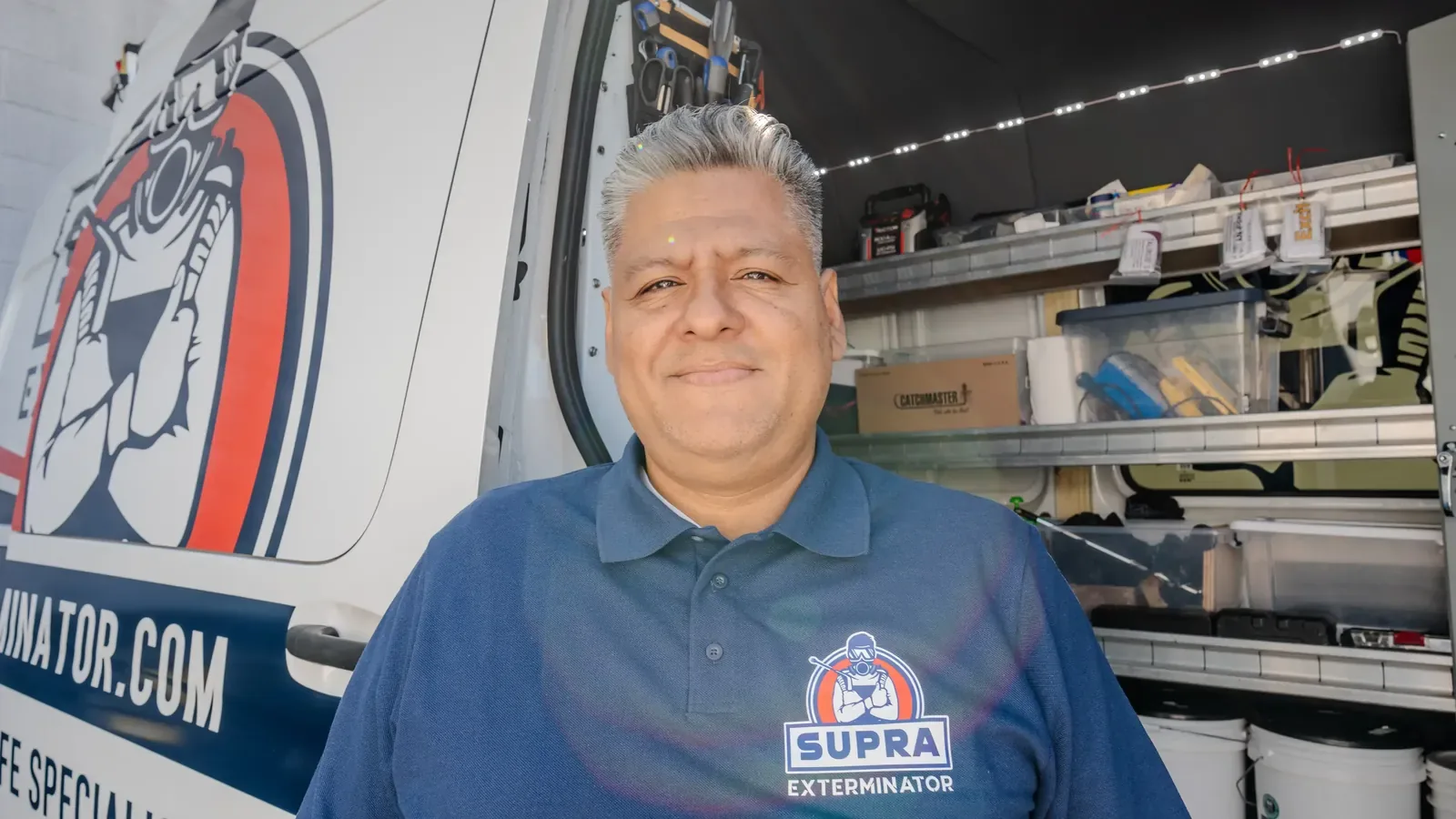 Supra Exterminator owner beside a service van